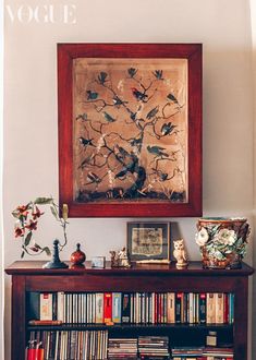 a bookshelf filled with lots of books next to a painting