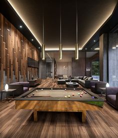 a pool table in the middle of a living room with couches and tables around it