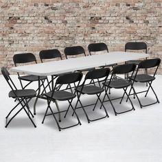 a long table with six chairs in front of a brick wall