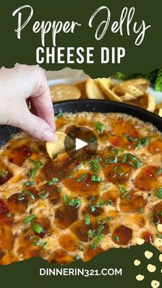 a person dipping cheese into a skillet with tortilla chips on the side