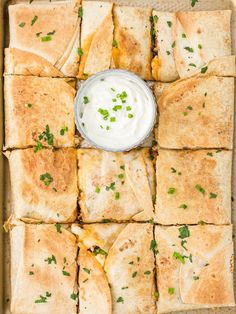 pita bread cut into squares with ranch dip in the middle and garnished with cilantro