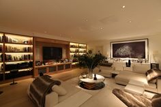 a living room filled with white furniture and lots of books on the shelves in front of it