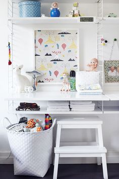 a white desk and shelf with various items on it in a room that looks like a child's playroom