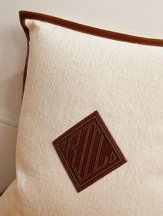 a close up of a pillow with a brown patch on it and a white wall in the background