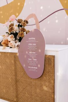 a vase filled with flowers sitting on top of a wooden shelf next to a wall