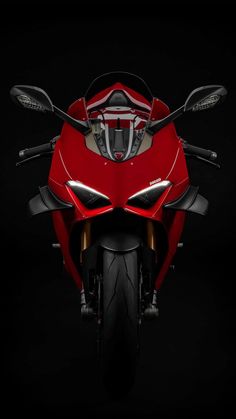 the front end of a red motorcycle on a black background