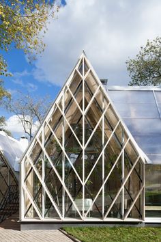 a glass house sitting on top of a lush green field