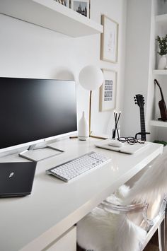 a white desk with a computer monitor and keyboard