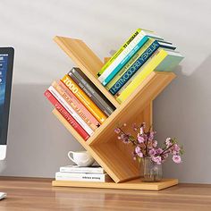 a computer monitor sitting on top of a desk next to a wooden shelf filled with books