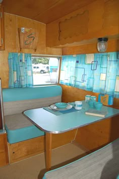 the inside of a small camper with a table and bench in front of it