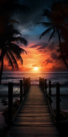 a pier leading to the ocean with palm trees in the foreground and a sunset behind it