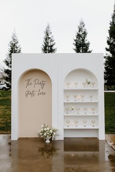 a couple of shelves that have flowers on them in front of some grass and trees