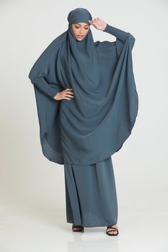 Indulge in the luxurious softness of our premium two-piece jilbab/prayer abaya set in dark charcoal blue. Crafted from high-quality nidha fabric, this two-piece jilbab drapes beautifully, providing a soft flow that feels like butter against your skin. The charcoal blue prayer abaya is also designed to last, with long-lasting quality that you can feel every time you wear it. Comfortable, simple and classy, our premium dark blue two-piece jilbab is perfectly lightweight, making it equally suitable for daily wear or prayers. Fabric - nidha (soft and lightweight) A jilbab is included. The headscarf is suitable for all face shapes and sizes. Simply use the tie backs to achieve the desired look. You can tie the tie backs over the headscarf or from inside An elasticated skirt is included. Simply Elasticated Skirt, Modest Wardrobe, Charcoal Blue, Blue Two Piece, Islamic Clothing, Abayas Fashion, Tie Backs, Head Scarf