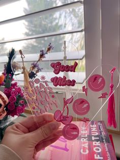 a person holding up some pink paper letters