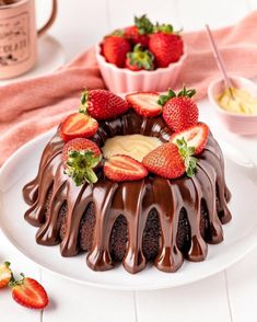 a bundt cake with chocolate frosting and strawberries on top, ready to be eaten