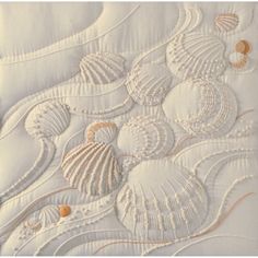 an image of seashells and shells on a white quilted piece of fabric