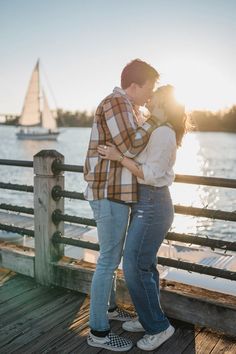 a man and woman standing on a dock near the water