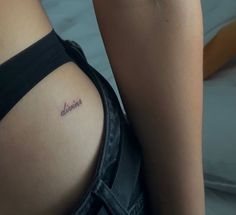 the back of a woman's thigh with a small tattoo on her left side