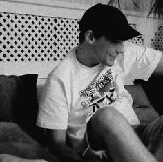 black and white photograph of a boy sitting on a couch