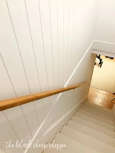 an overhead view of a stair case in a house with white walls and wood handrails