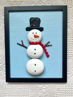 a snowman made out of rocks sitting on top of a table