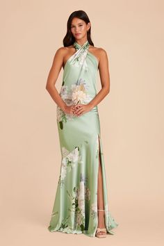 a woman in a green dress with flowers on the side and one leg slited