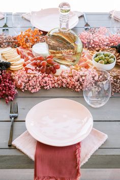 the table is set with plates, silverware, and wine bottle on it's side