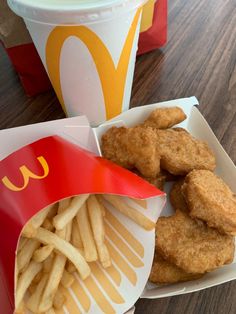 chicken nuggets and french fries on a plate next to a mcdonald's cup