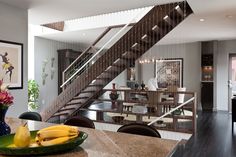 a bowl of bananas sitting on top of a counter next to a stair case in a living room