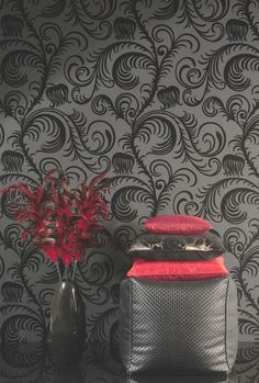 a black and white wallpaper with red flowers in a vase next to it on a table