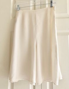 A clean and elegant silhouette, silk crepe de chine underlayer with silk georgette overlayer. High rise, contoured waist with center back zip. Color Ivory, size 10. Waist 29" circumference, 8" inseam, garment length 22". White Silk Bottoms For Spring, White Silk Summer Bottoms, White Silk Bottoms For Summer, Silk Flowy Skirt For Workwear, Elegant White Silk Bottoms, Spring Silk Cream Bottoms, Cream Silk Bottoms For Spring, Spring Cream Silk Bottoms, Elegant Cream Lined Skirt Bottoms