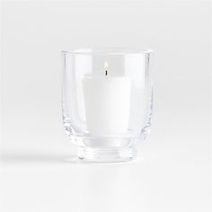 a white candle in a clear glass bowl