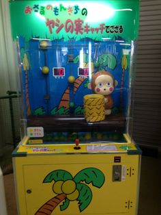 an arcade machine with a monkey on it's front and palm trees in the back