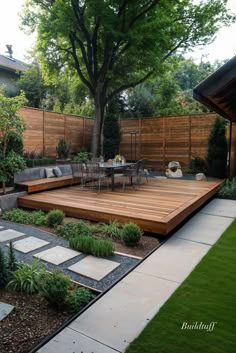 a wooden deck in the middle of a garden with seating area and trees on either side