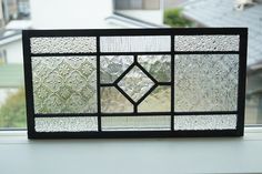 a close up of a stained glass window with buildings in the background