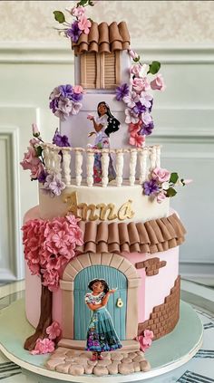 a three tiered cake is decorated with flowers and an image of princess on top