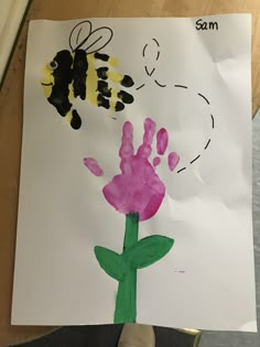 a child's handprint with a flower and a bee on it