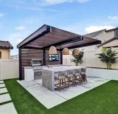 an outdoor kitchen and grill area with grass