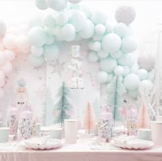 a table set up for a princess party with balloons in the shape of snowflakes