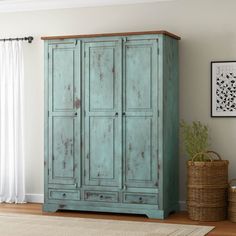 an old blue armoire in the corner of a room with a rug on the floor