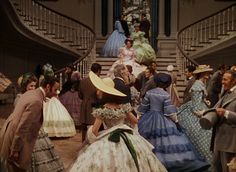 many people in dresses and hats are walking up the stairs