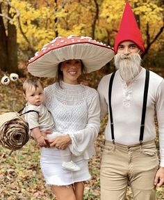 a man and woman are dressed up as gnomes with a baby in their arms