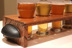 five glasses of beer are lined up on a shelf