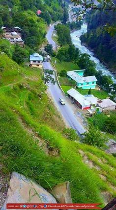 an aerial view of a small village on the side of a mountain with a river running through it