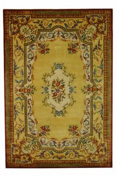 a yellow rug with an ornate design on the center and sides, in various colors