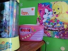 there is a pink alarm clock on the table next to a cupcake and other toys