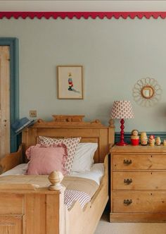 a bedroom with blue walls and wooden furniture