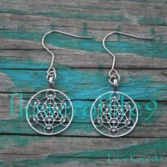 the earrings are made from silver wire and have an intricate flower design on each side