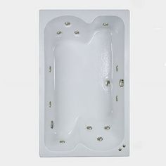 a white bath tub sitting in the middle of a wall with three holes on it