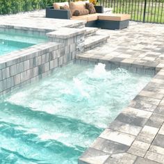 an outdoor hot tub in the middle of a patio with stone steps leading up to it